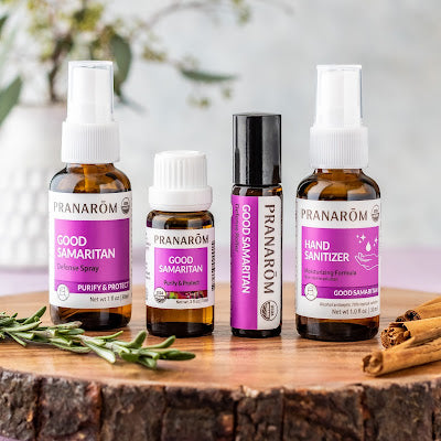 Pranarom Certified Organic Good Samaritan Defense Spray, Wellness Formula, Defense Roller, and Hand Sanitizer bottles and rosemary and cinnamon sprigs.