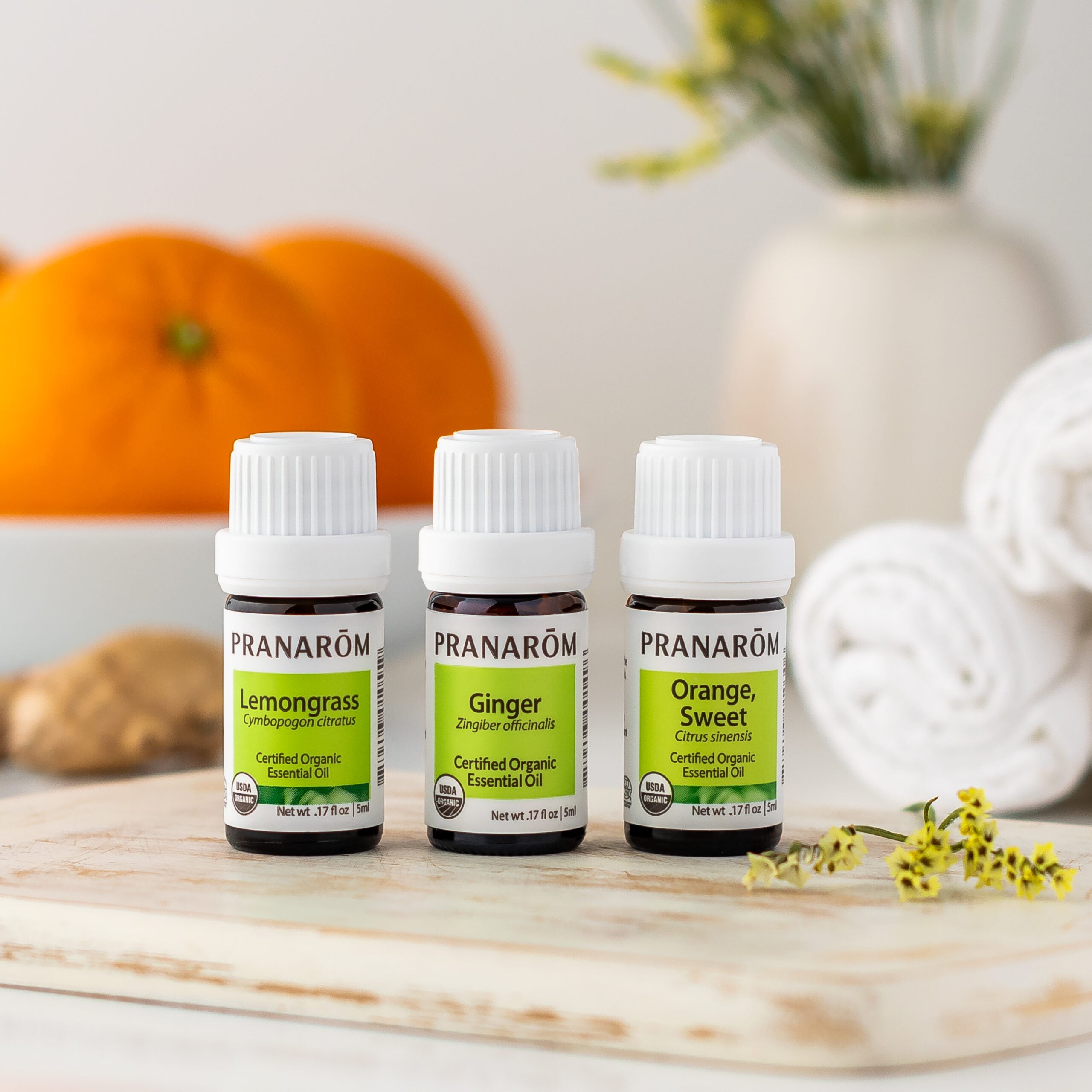 Pranarom Certified Organic Lemongrass, Ginger, and Orange, Sweet Essential Oil bottles with oranges and ginger background.