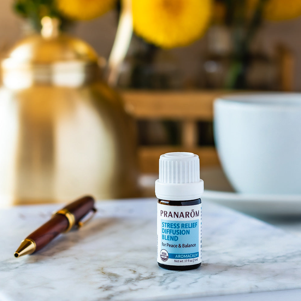 Pranarom Certified Organic Aromacalm Stress Relief Diffusion Blend with pen and white table.