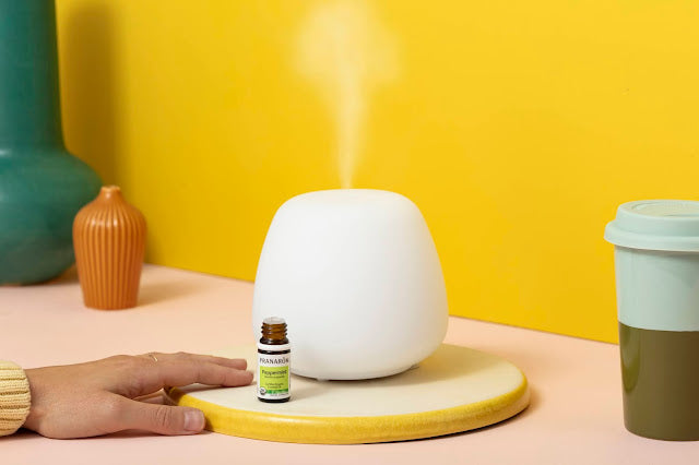 Pranarom Certified Organic Peppermint Essential Oil bottle and diffuser with yellow background.
