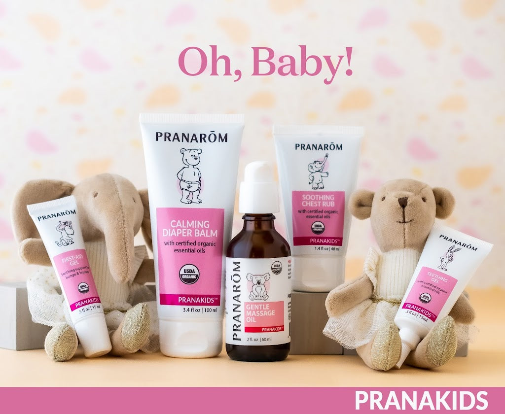 Pranarom Certified Organic PranaKids First-Aid Gel, Calming Diaper Balm, Gentle Massage Oil, Soothing Chest Rub, and Teething Gel bottles with stuffed animals.